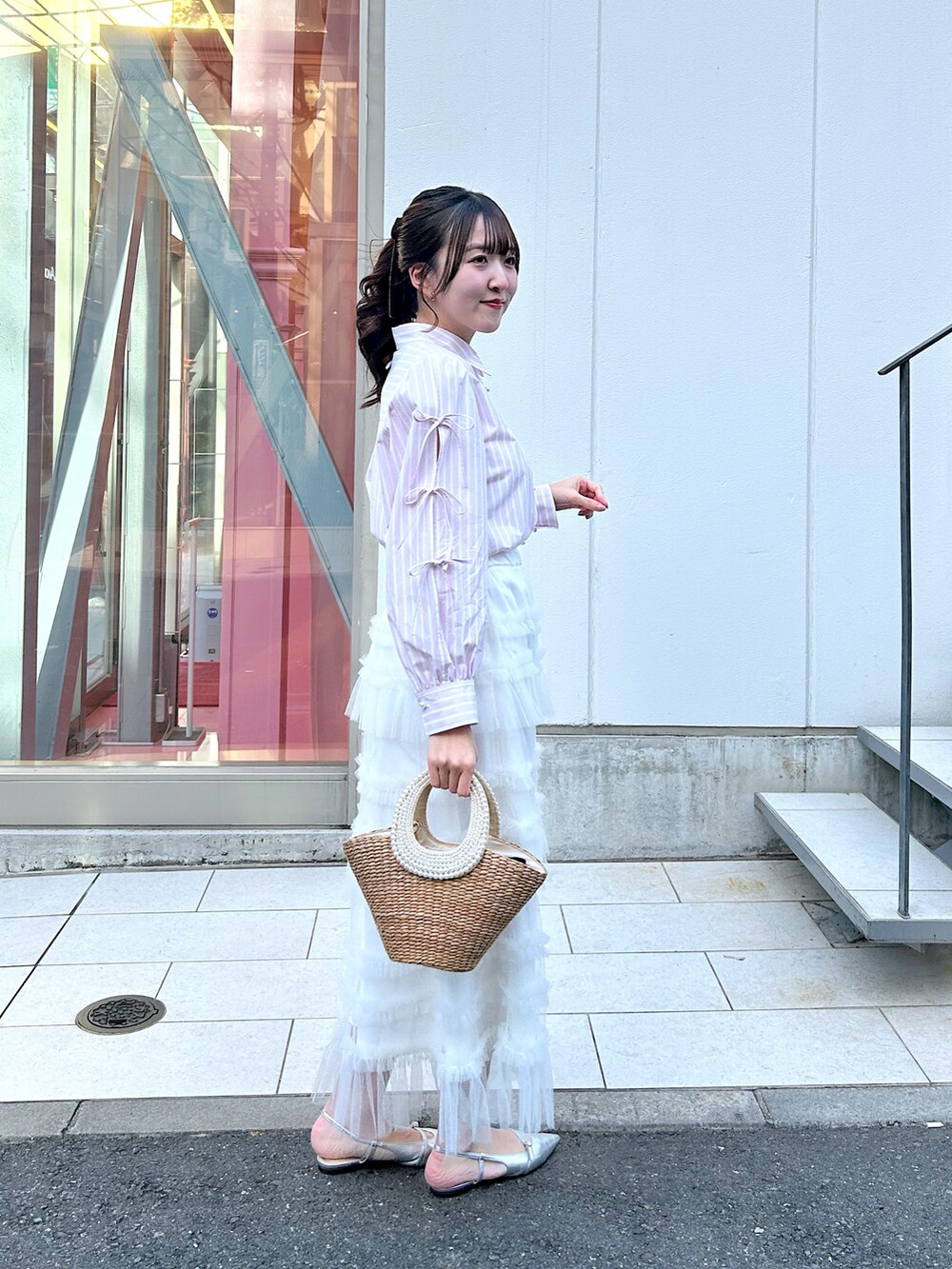 ピンク系のシャツ/ブラウス、ホワイト系のスカート、ベージュ系のかごバッグを着用したレディースの冬コーディネートの2枚目の写真