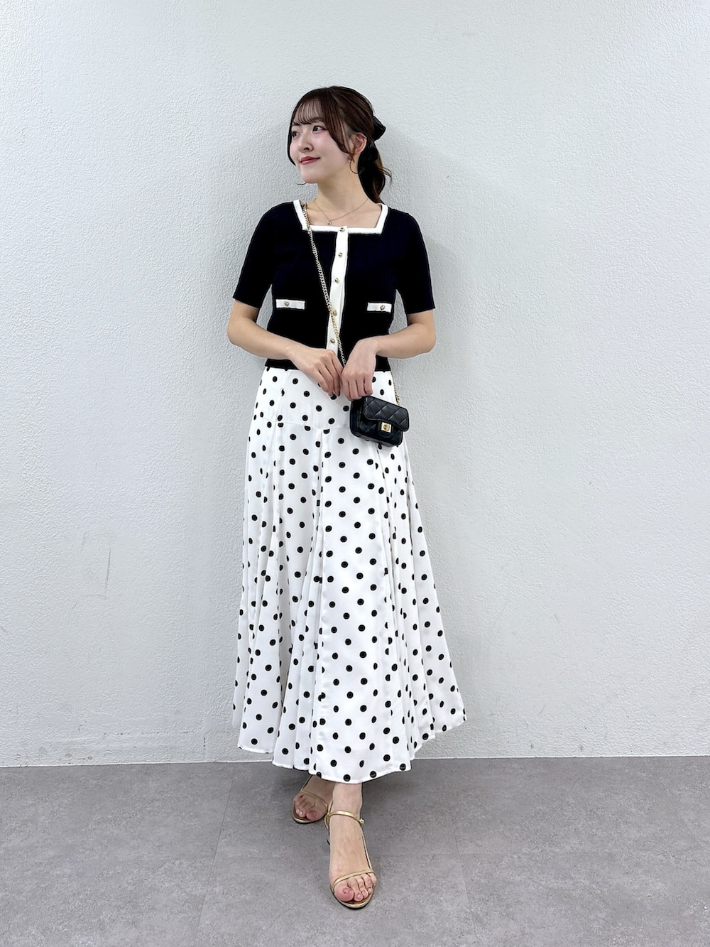 ブルー系のニット/セーター、ホワイト系のスカートを着用したレディースの春コーディネートの4枚目の写真