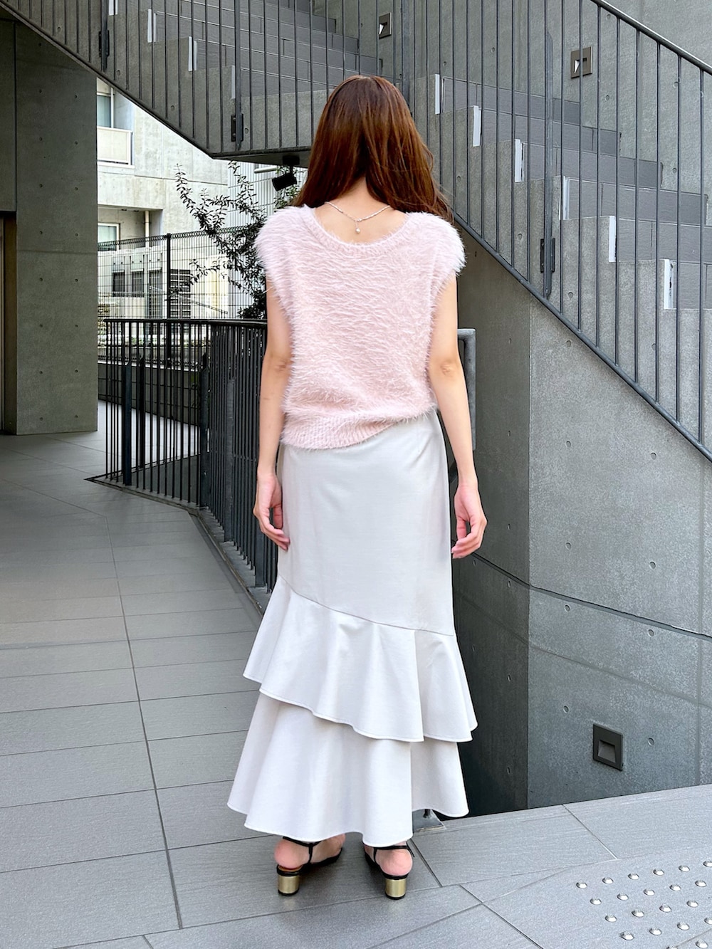 ピンク系のベスト、ベージュ系のスカートを着用したレディースの夏コーディネートの3枚目の写真