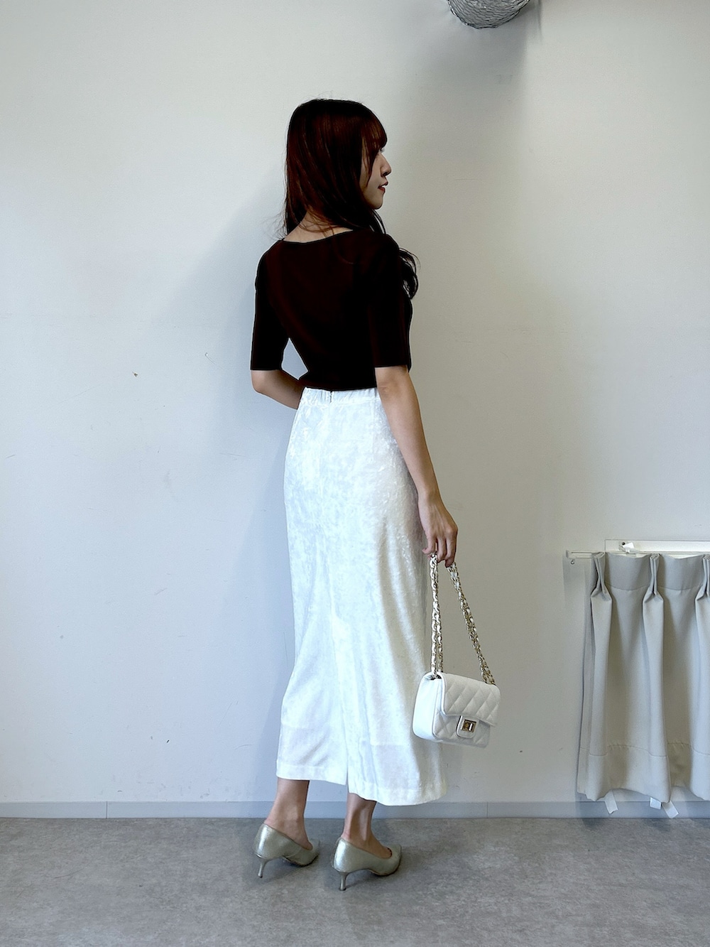 ブラウン系のニット/セーター、ホワイト系のスカートを着用したレディースの夏コーディネートの3枚目の写真