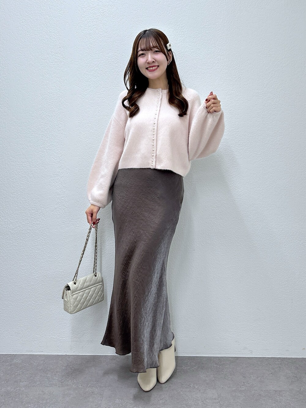 ピンク系のカーディガン/ボレロ、ブラウン系のスカートを着用したレディースの秋コーディネートの4枚目の写真