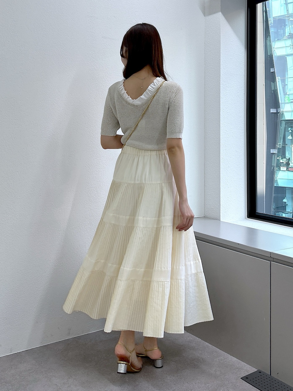 ベージュ系のニット/セーター、ホワイト系のスカートを着用したレディースの春コーディネートの3枚目の写真