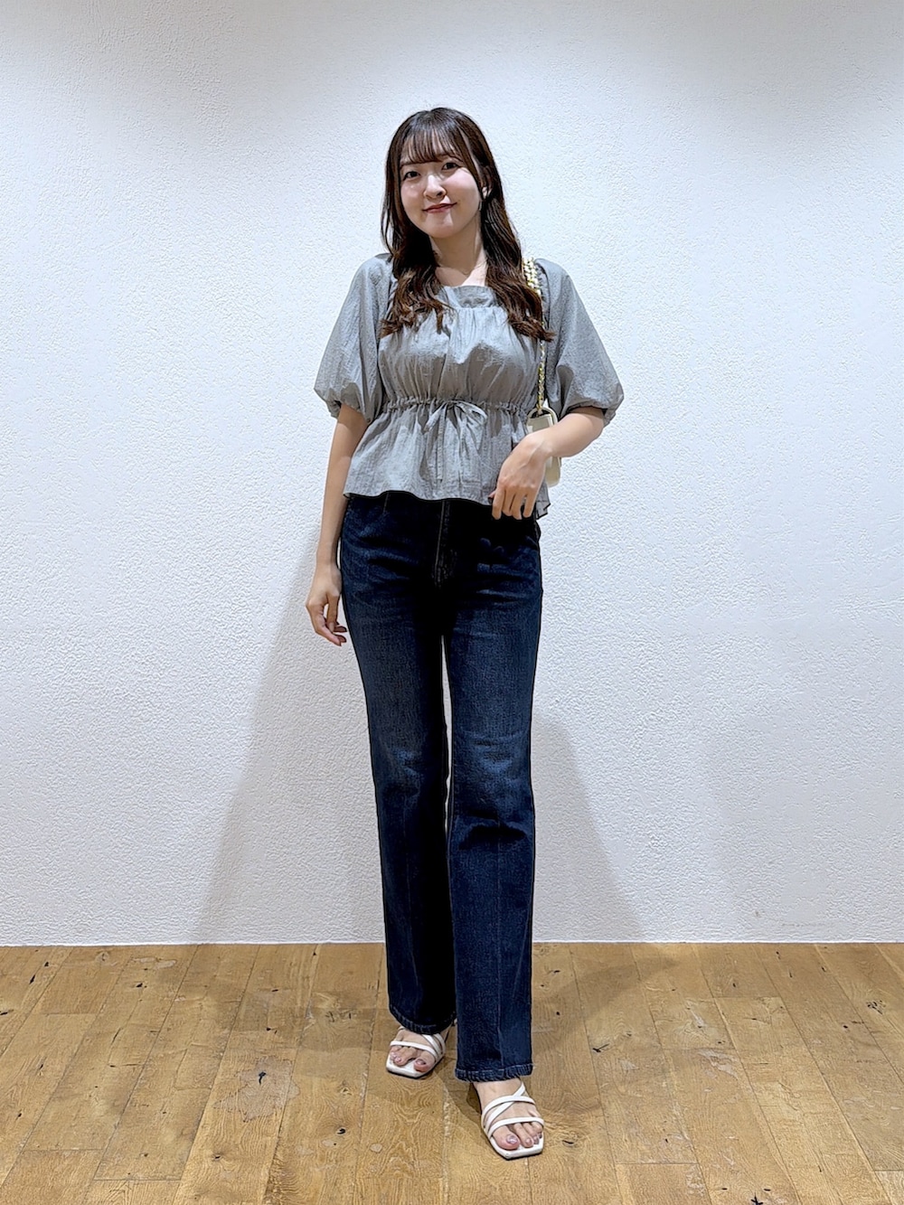 グレー系のシャツ/ブラウス、ブルー系のデニムパンツを着用したレディースの秋コーディネートの4枚目の写真