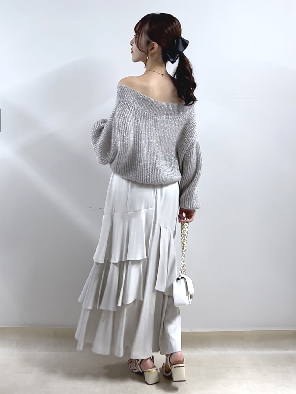 シルバー系のニット/セーター、グレー系のスカートを着用したレディースの秋コーディネートの3枚目の写真