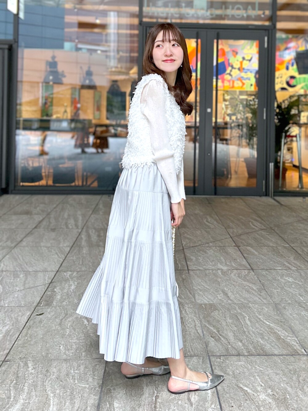 ホワイト系のシャツ/ブラウス、グレー系のスカート、ホワイト系のニット/セーターを着用したレディースの春コーディネートの3枚目の写真