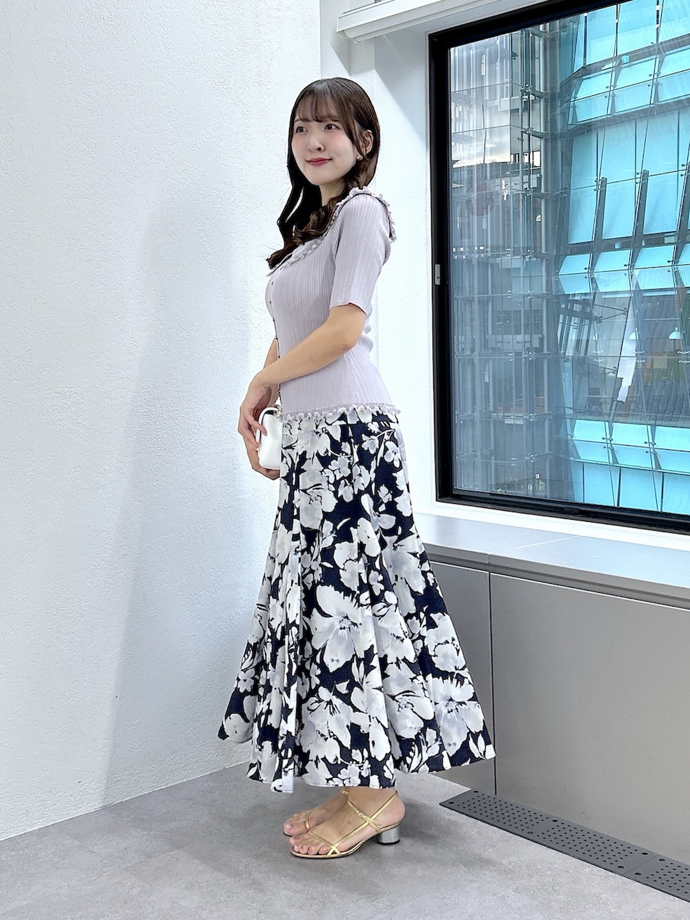 パープル系のニット/セーター、ブルー系のスカートを着用したレディースの夏コーディネートの2枚目の写真