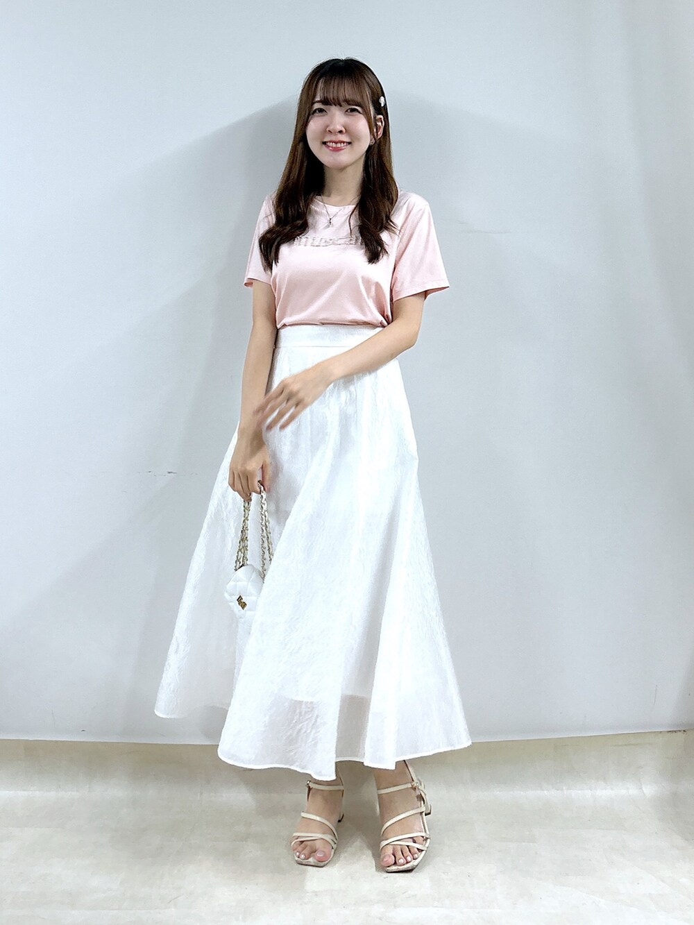 ピンク系のTシャツ/カットソー、ホワイト系のスカートを着用したレディースの夏コーディネートの4枚目の写真