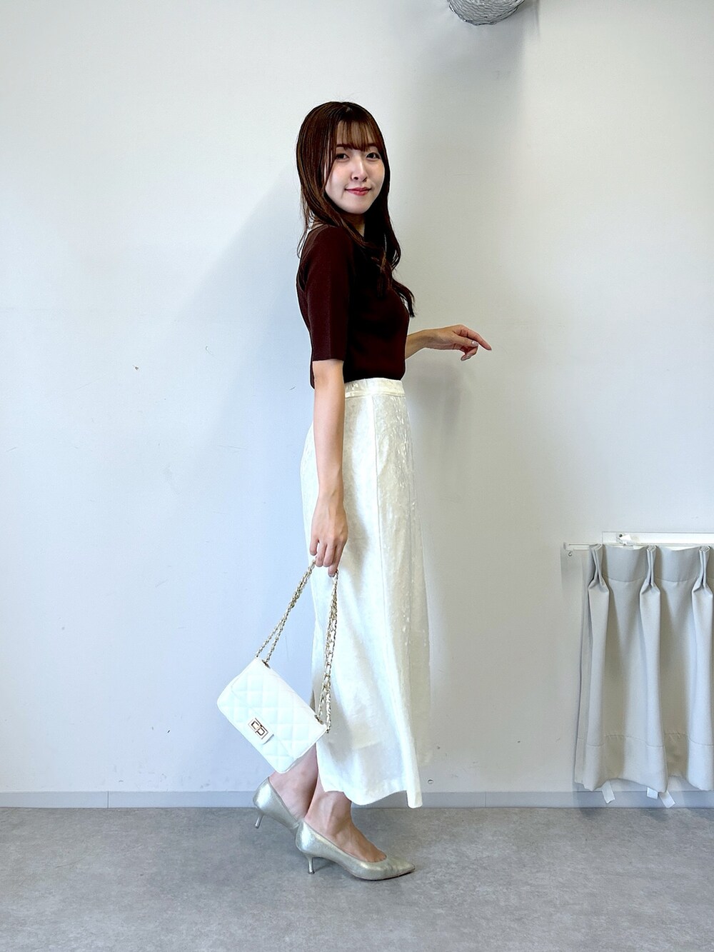 ブラウン系のニット/セーター、ホワイト系のスカートを着用したレディースの夏コーディネートの2枚目の写真