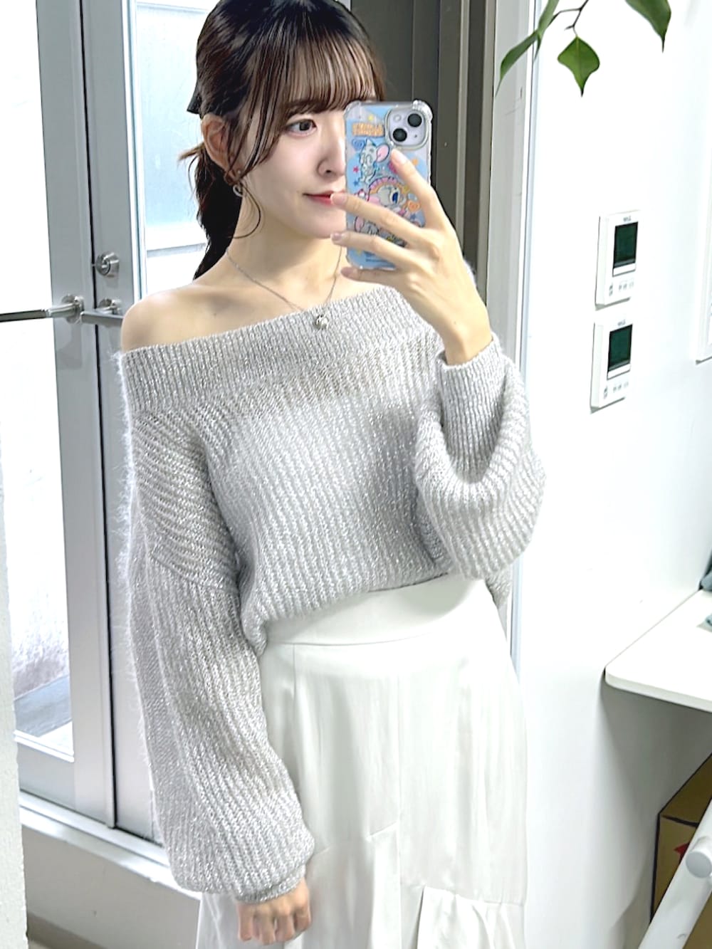 シルバー系のニット/セーター、グレー系のスカートを着用したレディースの秋コーディネートの4枚目の写真