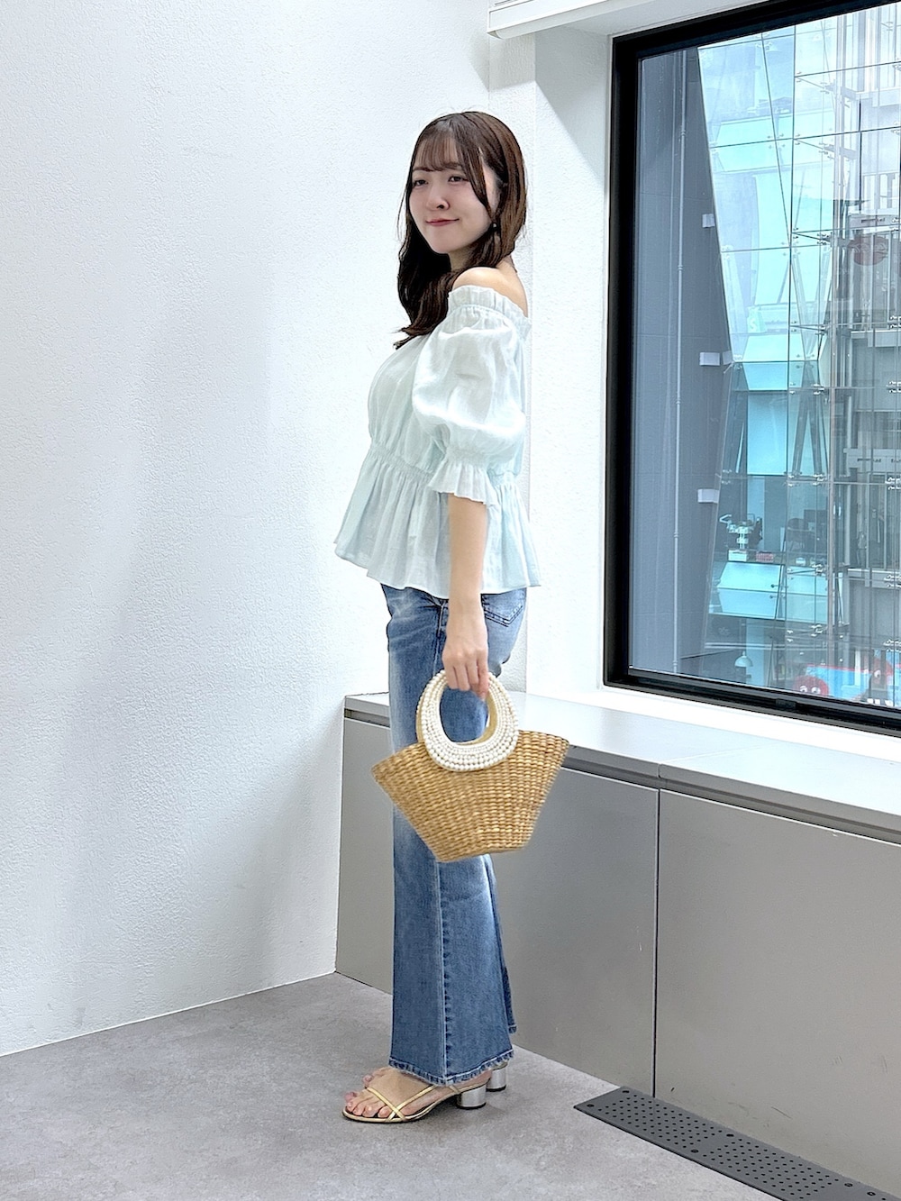 グリーン系のシャツ/ブラウス、ブルー系のデニムパンツを着用したレディースの春コーディネートの2枚目の写真