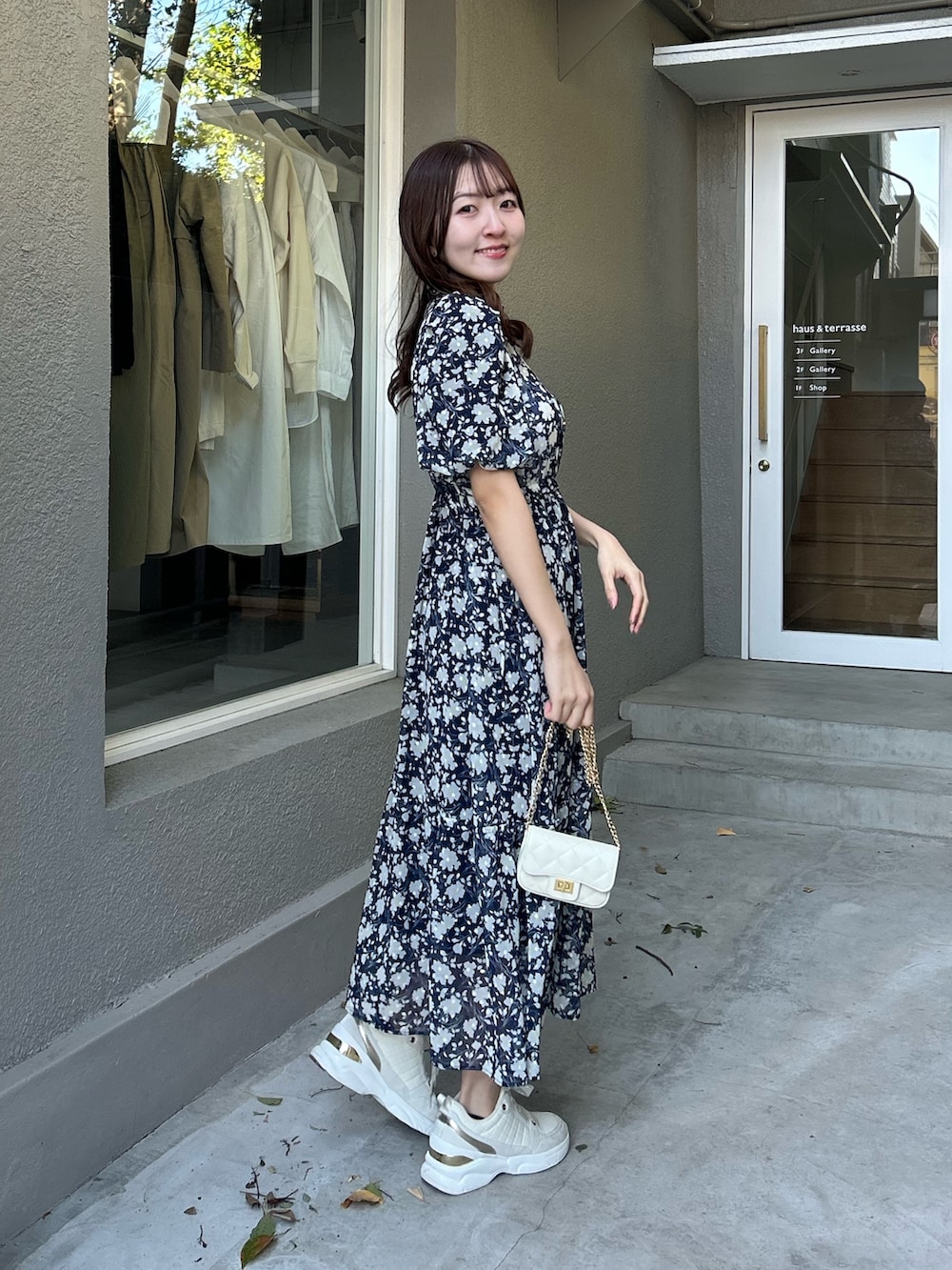 ブルー系のワンピースを着用したレディースの春コーディネートの2枚目の写真