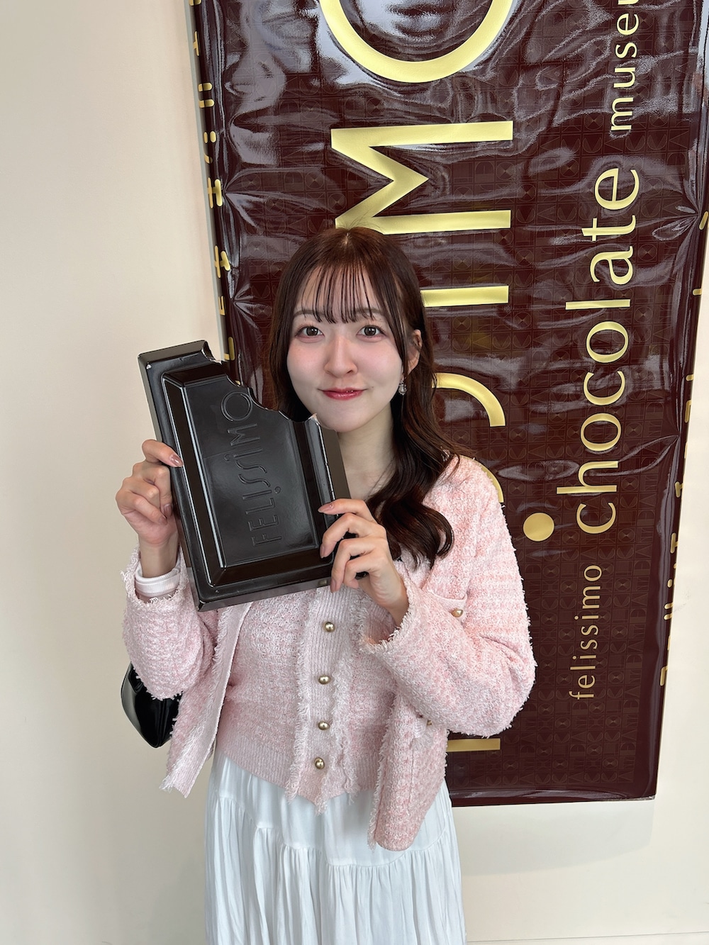 ピンク系のニット/セーター、ピンク系のニット/セーター、ホワイト系のスカートを着用したレディースの春コーディネートの3枚目の写真