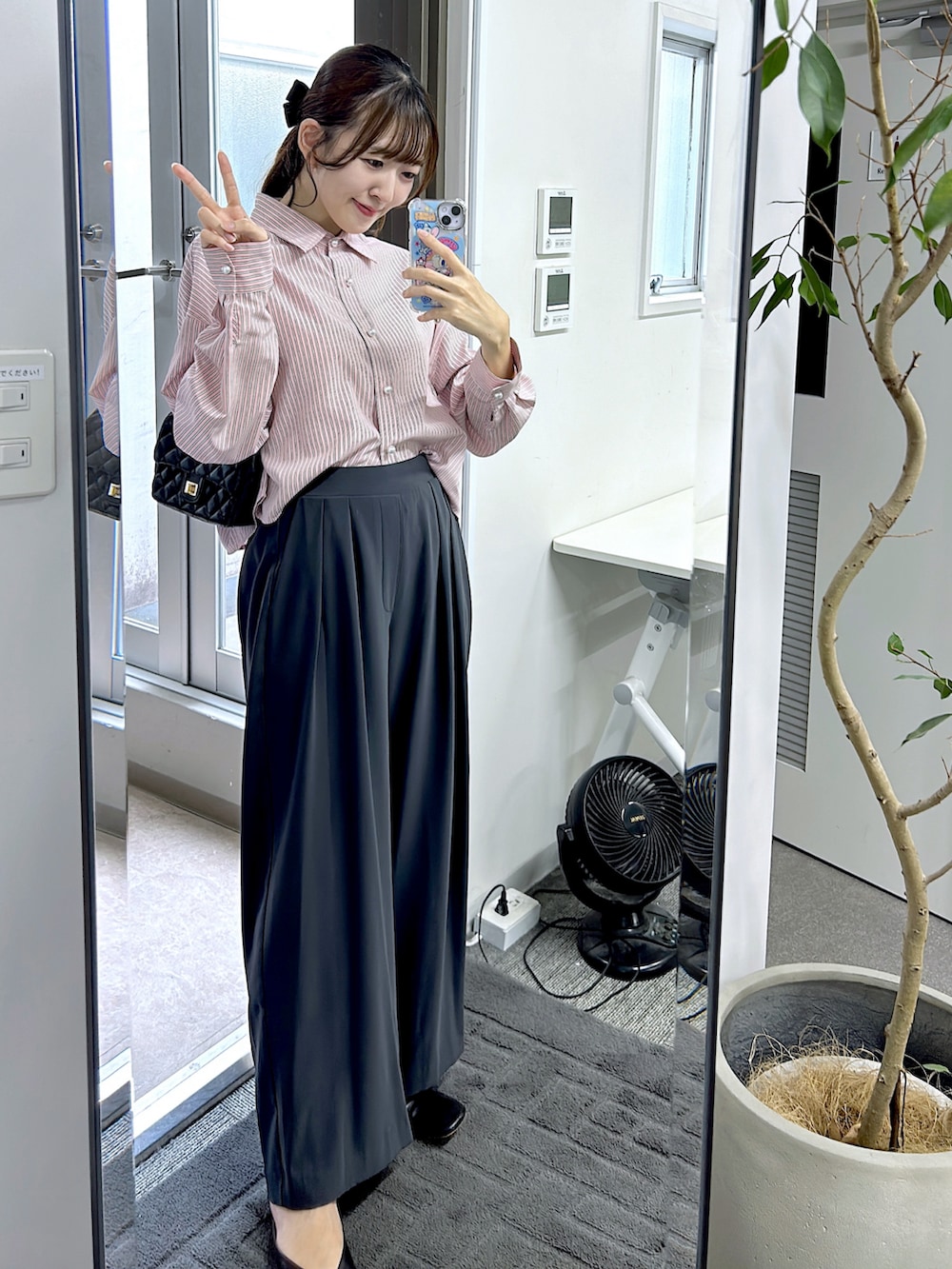 ピンク系のシャツ/ブラウス、グレー系のスラックスを着用したレディースの秋コーディネートの2枚目の写真