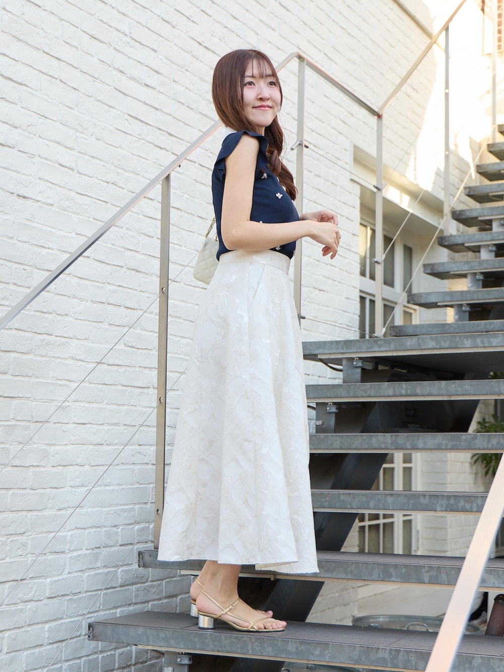 ブルー系のニット/セーター、ホワイト系のスカートを着用したレディースの春コーディネートの3枚目の写真
