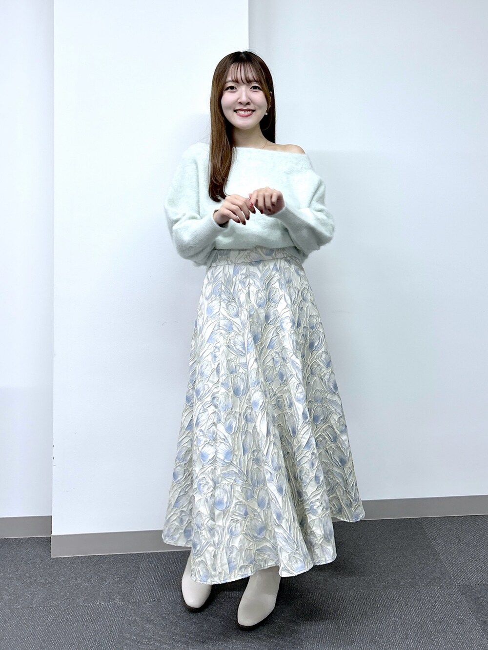 グリーン系のニット/セーター、ブルー系のスカートを着用したレディースの秋コーディネートの2枚目の写真