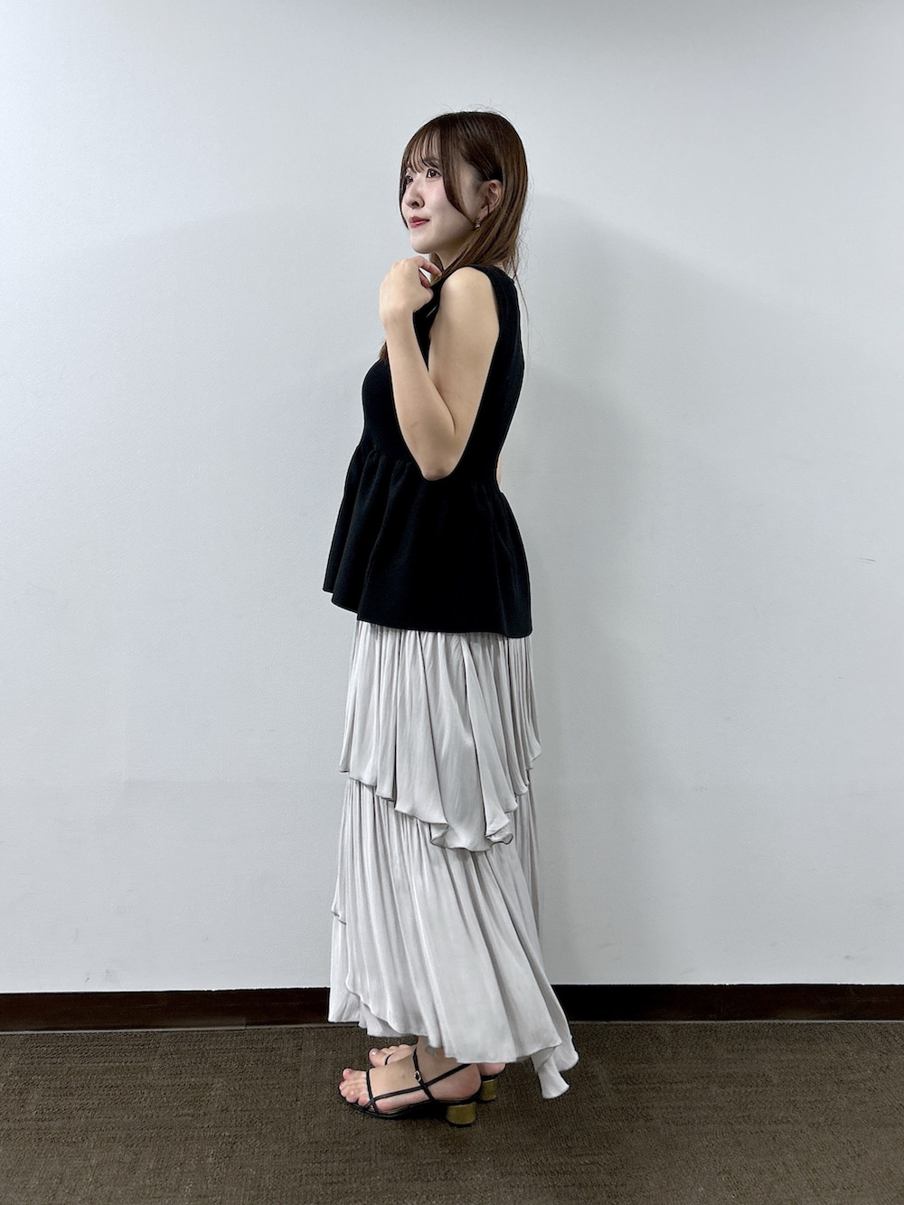 ブラック系のニット/セーター、グレー系のスカートを着用したレディースの春コーディネートの2枚目の写真