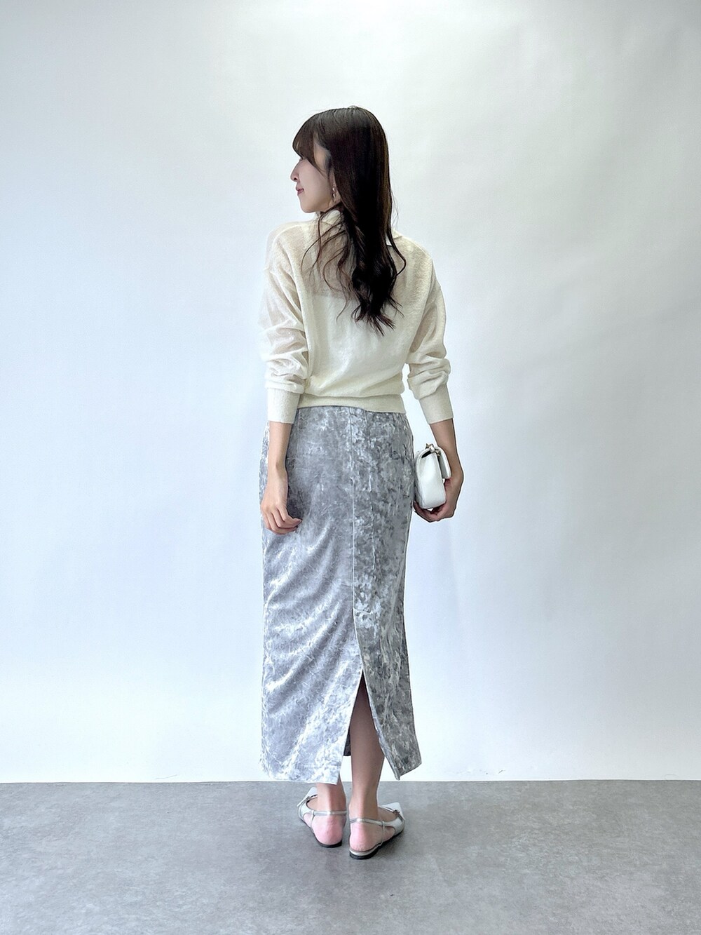 ホワイト系のニット/セーター、グレー系のスカートを着用したレディースの夏コーディネートの3枚目の写真