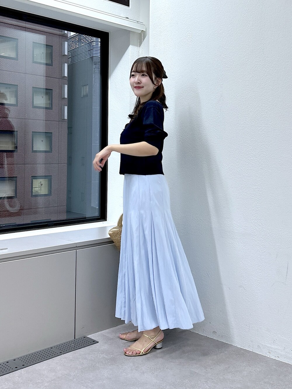 ブルー系のニット/セーター、ブルー系のスカートを着用したレディースの春コーディネートの2枚目の写真