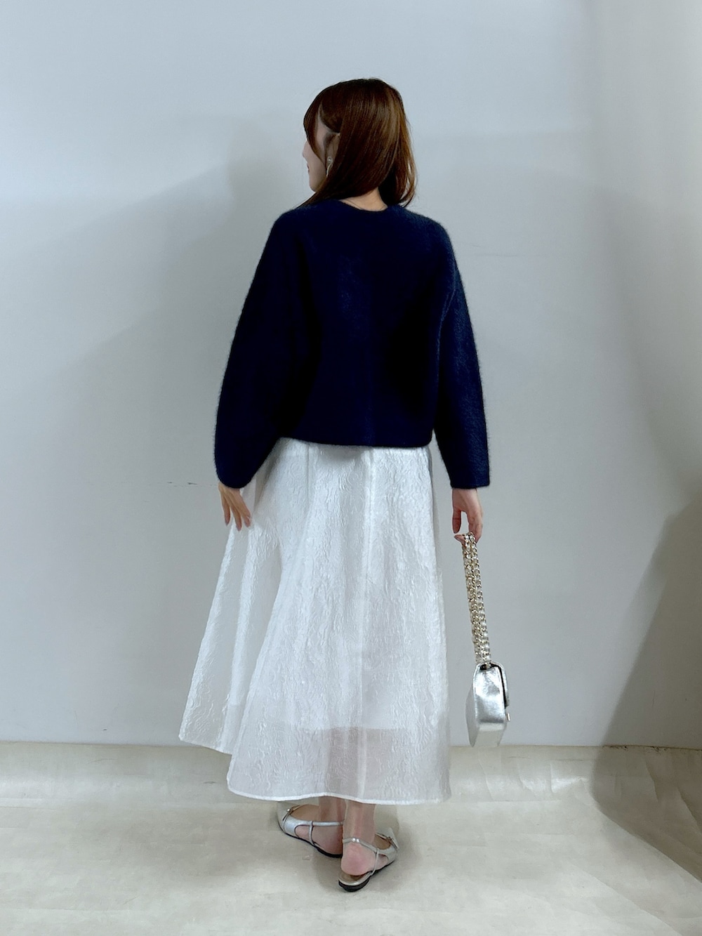 ブルー系のノーカラージャケット、ホワイト系のスカートを着用したレディースの夏コーディネートの3枚目の写真