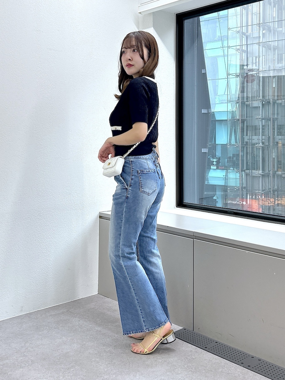 ブルー系のニット/セーター、ブルー系のデニムパンツを着用したレディースの春コーディネートの2枚目の写真