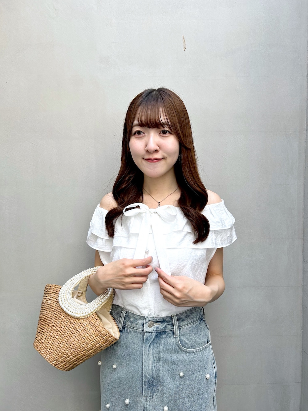 ホワイト系のシャツ/ブラウス、ブルー系のスカート、ベージュ系のかごバッグを着用したレディースの春コーディネートの6枚目の写真