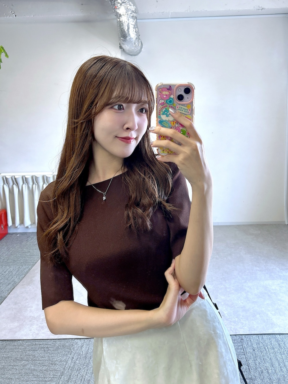 ブラウン系のニット/セーター、ホワイト系のスカートを着用したレディースの夏コーディネートの4枚目の写真