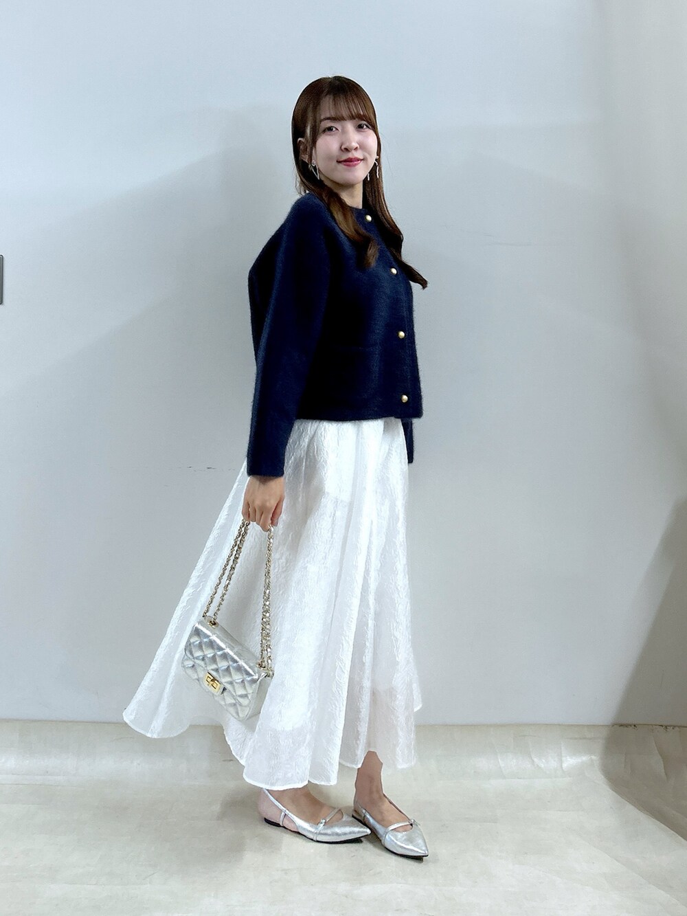 ブルー系のノーカラージャケット、ホワイト系のスカートを着用したレディースの夏コーディネートの4枚目の写真