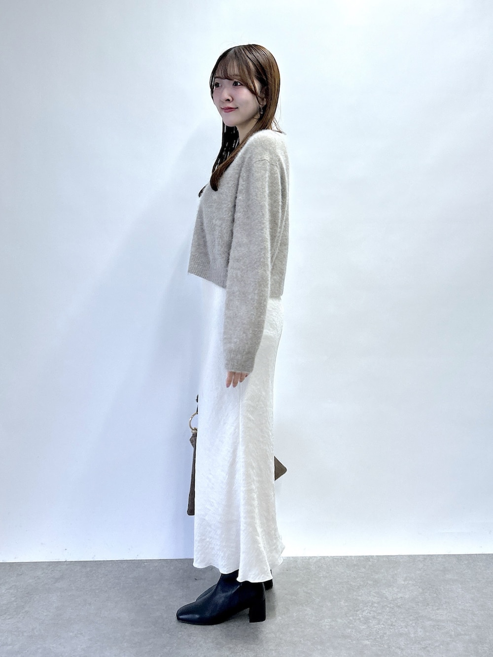 ブラウン系のカーディガン/ボレロ、グレー系のスカートを着用したレディースの秋コーディネートの2枚目の写真