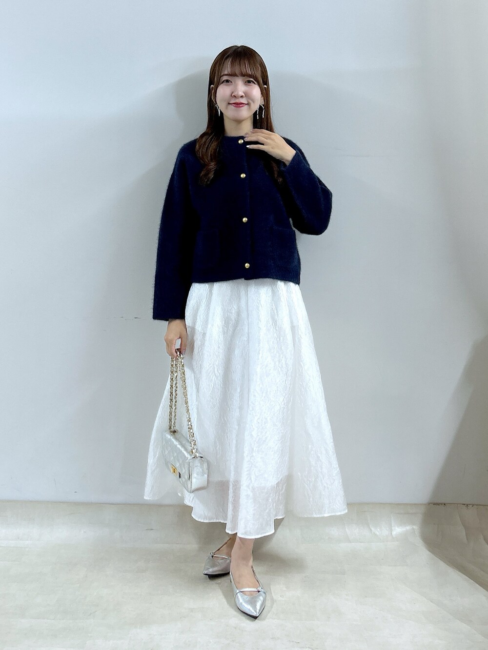 ブルー系のノーカラージャケット、ホワイト系のスカートを着用したレディースの夏コーディネートの5枚目の写真