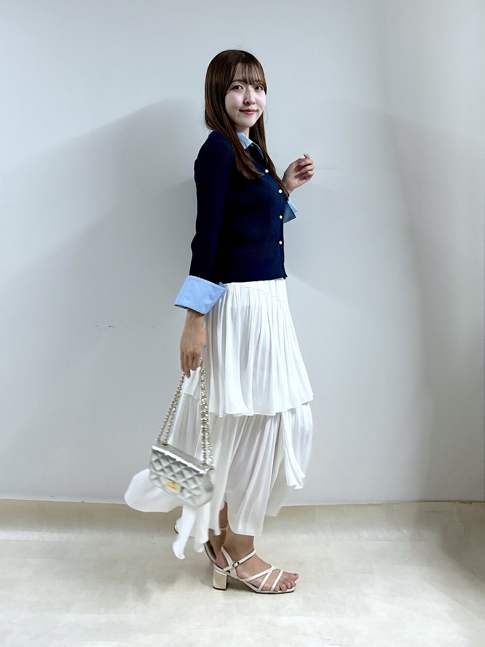 ブルー系のニット/セーター、ホワイト系のスカートを着用したレディースの秋コーディネートの3枚目の写真