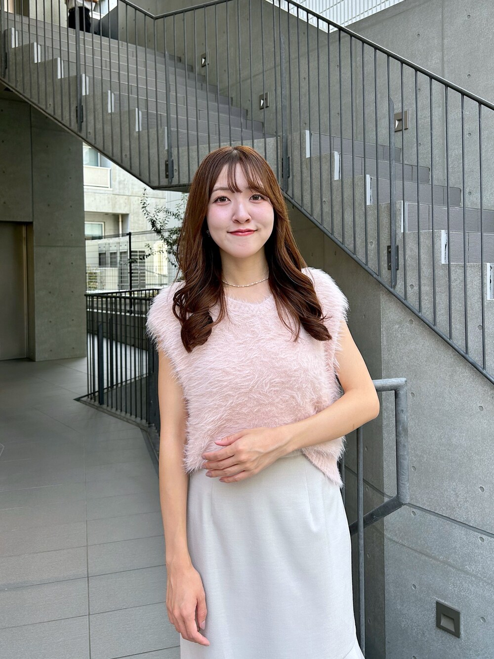 ピンク系のベスト、ベージュ系のスカートを着用したレディースの夏コーディネートの5枚目の写真