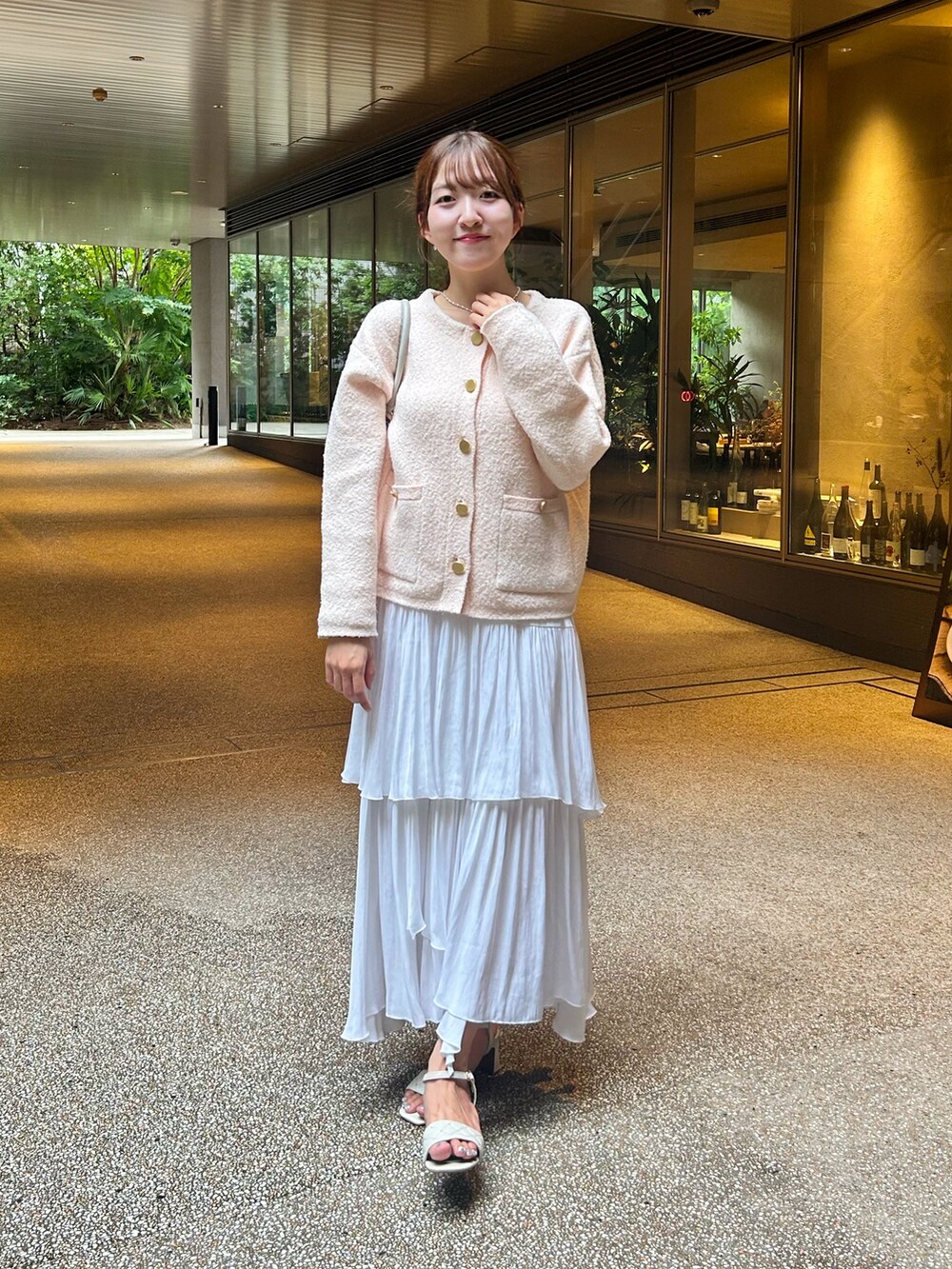 ピンク系のノーカラージャケット、ホワイト系のスカート、ホワイト系のサンダルを着用したレディースの秋コーディネートの5枚目の写真