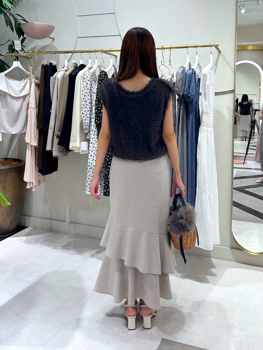 グレー系のベスト、ベージュ系のスカートを着用したレディースの夏コーディネートの4枚目の写真