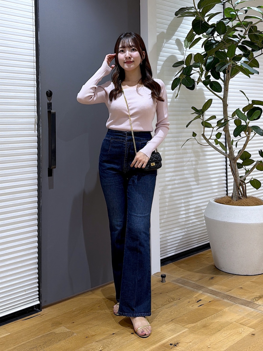 ピンク系のニット/セーター、ブルー系のデニムパンツを着用したレディースの秋コーディネートの4枚目の写真