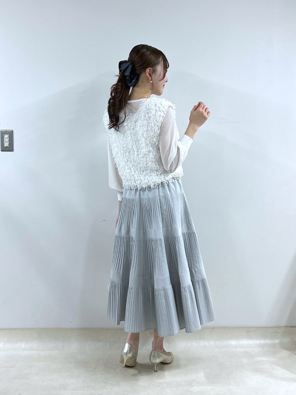 ホワイト系のシャツ/ブラウス、グレー系のスカート、ホワイト系のニット/セーターを着用したレディースの冬コーディネートの3枚目の写真