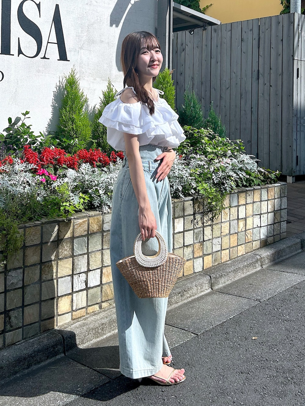 ホワイト系のシャツ/ブラウス、ブルー系のデニムパンツ、ベージュ系のかごバッグを着用したレディースの春コーディネートの2枚目の写真