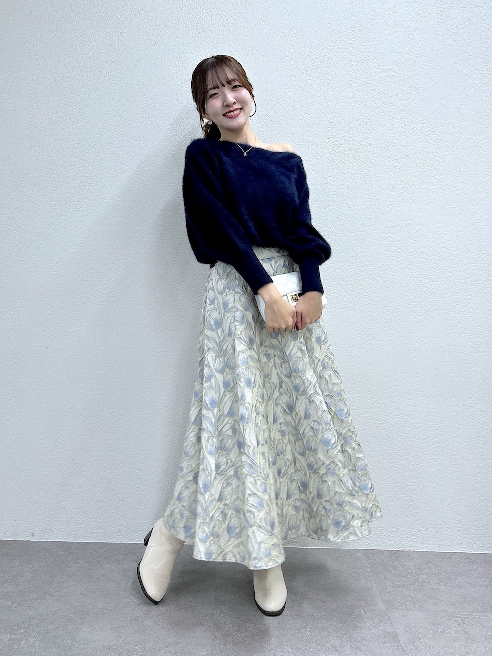ブルー系のニット/セーター、ブルー系のスカートを着用したレディースの冬コーディネートの2枚目の写真