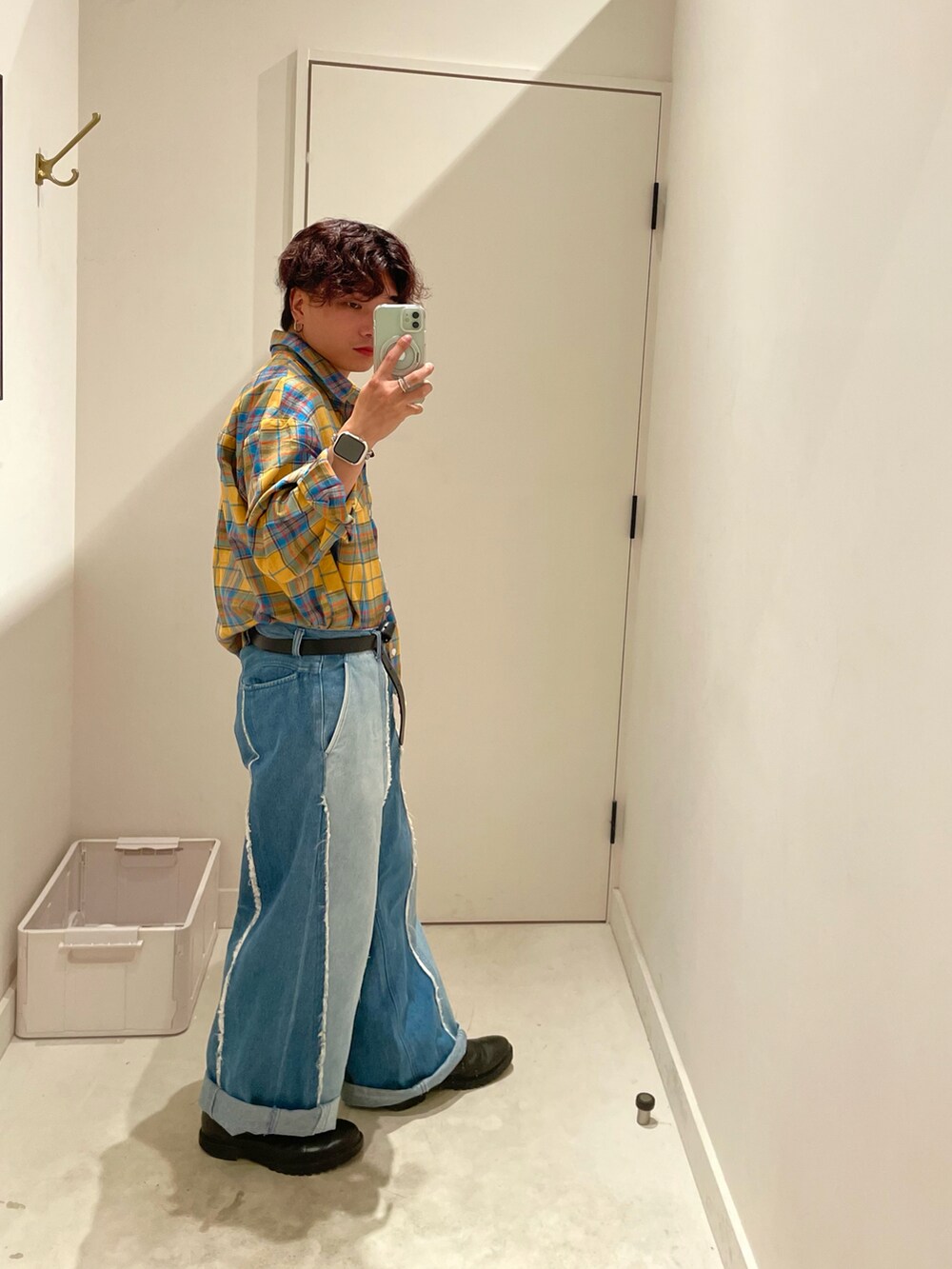 ブルー系のデニムパンツ、ブラック系のシューズ、シルバー系のネックレスを着用したメンズの秋コーディネートの3枚目の写真