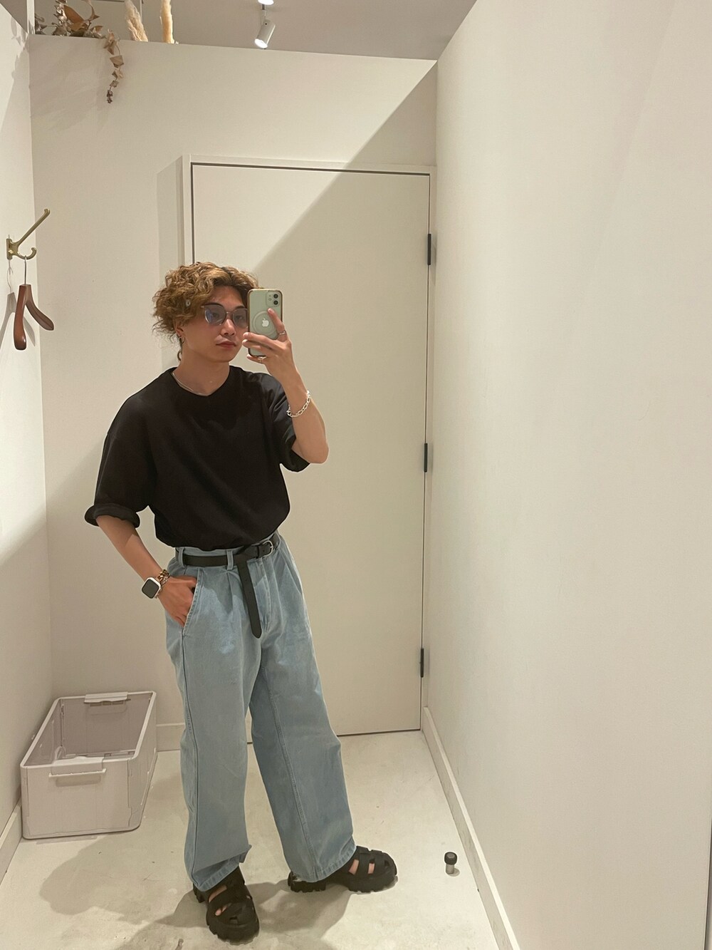 ブラック系のTシャツ/カットソー、ブルー系のデニムパンツ、ブラック系のサンダルを着用したメンズの夏コーディネートの2枚目の写真