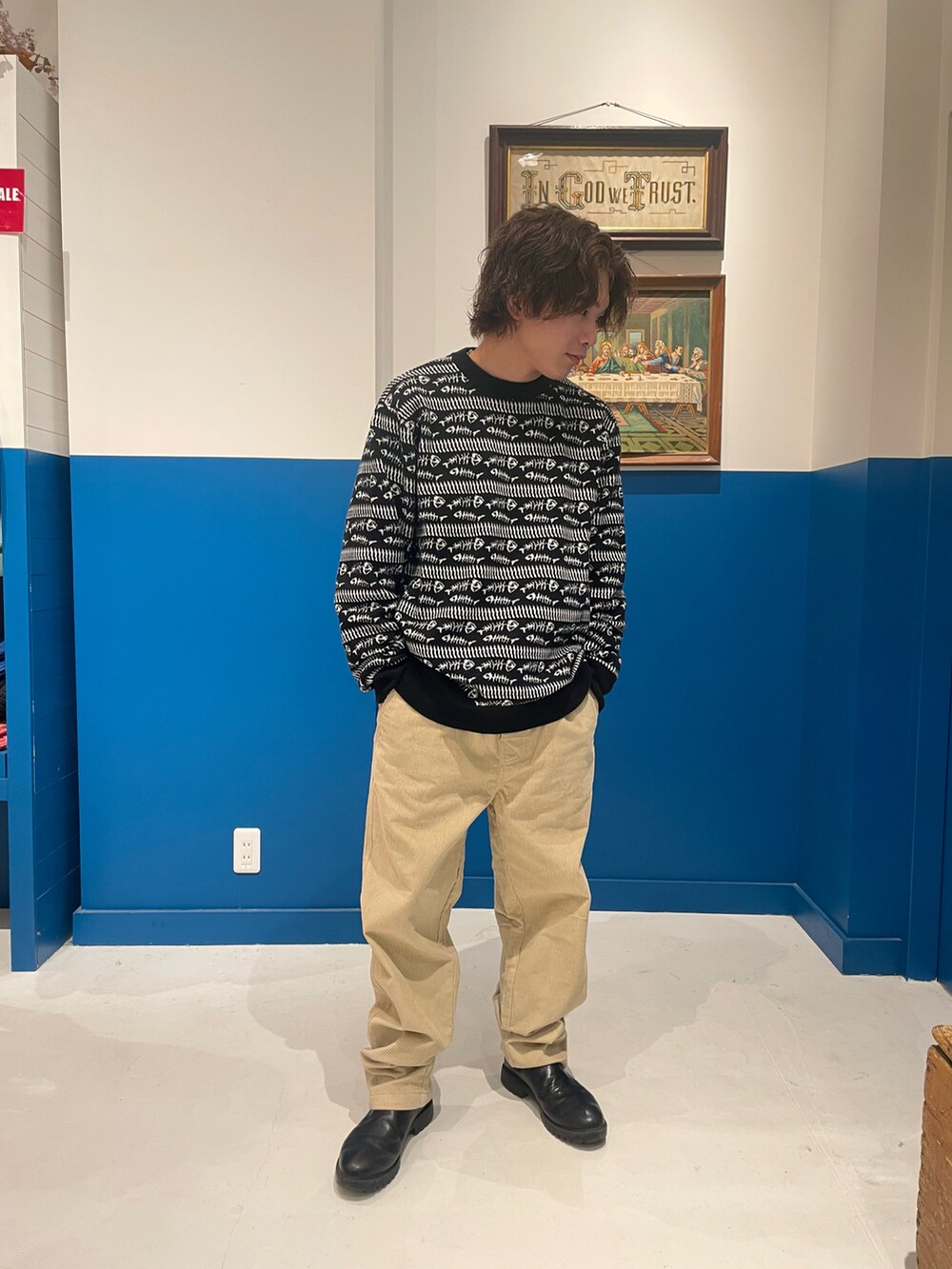 ブラック系のニット/セーター、ベージュ系のパンツを着用したメンズの冬コーディネートの2枚目の写真