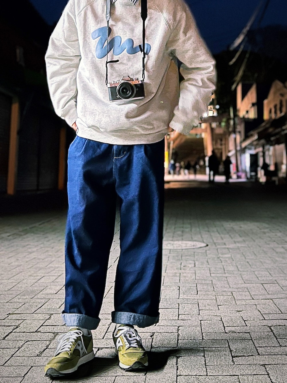 ブルー系のデニムパンツ、グリーン系のスニーカー、グレー系のスウェットを着用したメンズの冬コーディネートの2枚目の写真