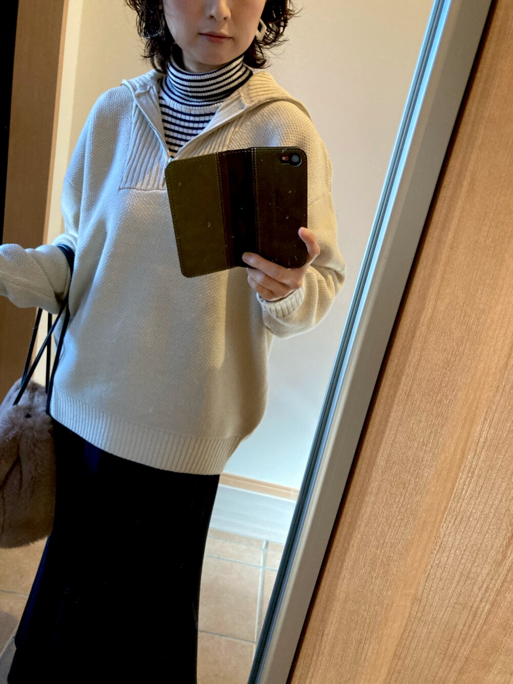 ベージュ系のニット/セーター、ホワイト系のニット/セーター、ベージュ系のショルダーバッグを着用したレディースの冬コーディネートの2枚目の写真