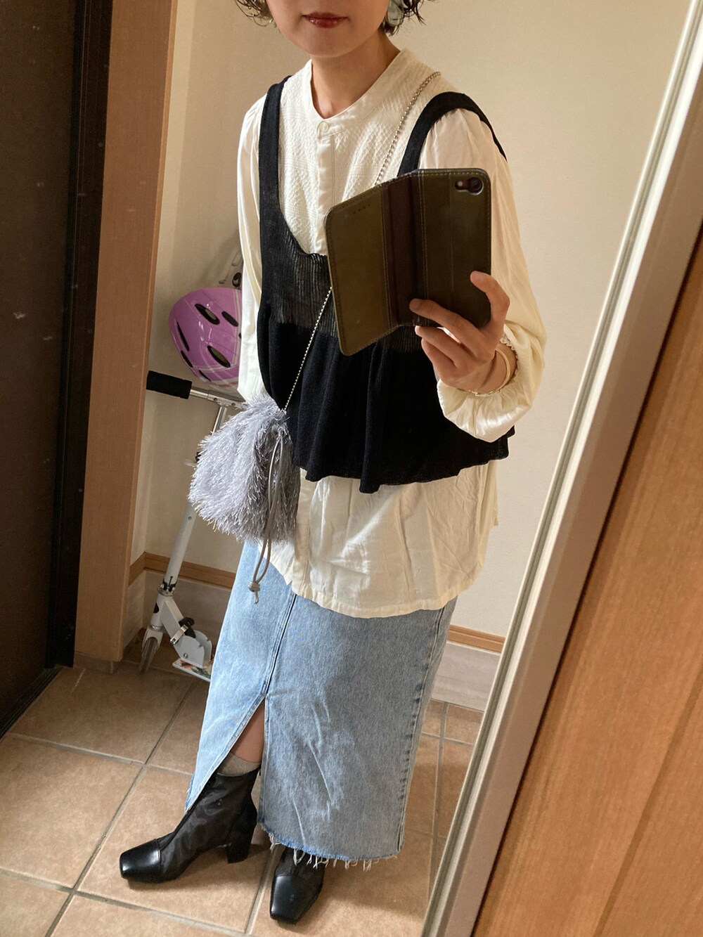 ベージュ系のシャツ/ブラウス、ブラック系のベスト、ブルー系のスカートを着用したレディースの夏コーディネートの2枚目の写真