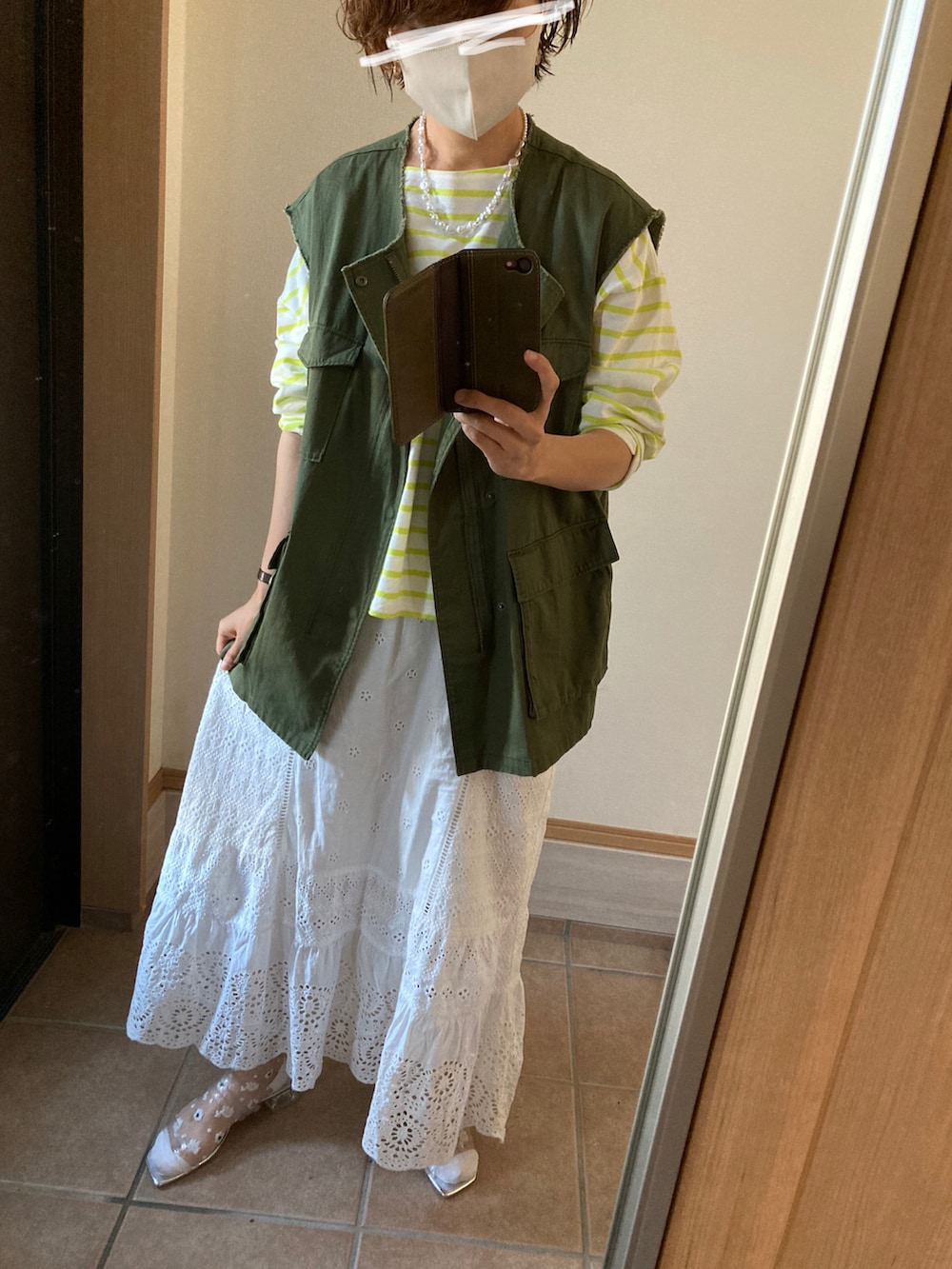 グリーン系のその他アウター、イエロー系のTシャツ/カットソー、ホワイト系のスカートを着用したレディースの春コーディネートの2枚目の写真