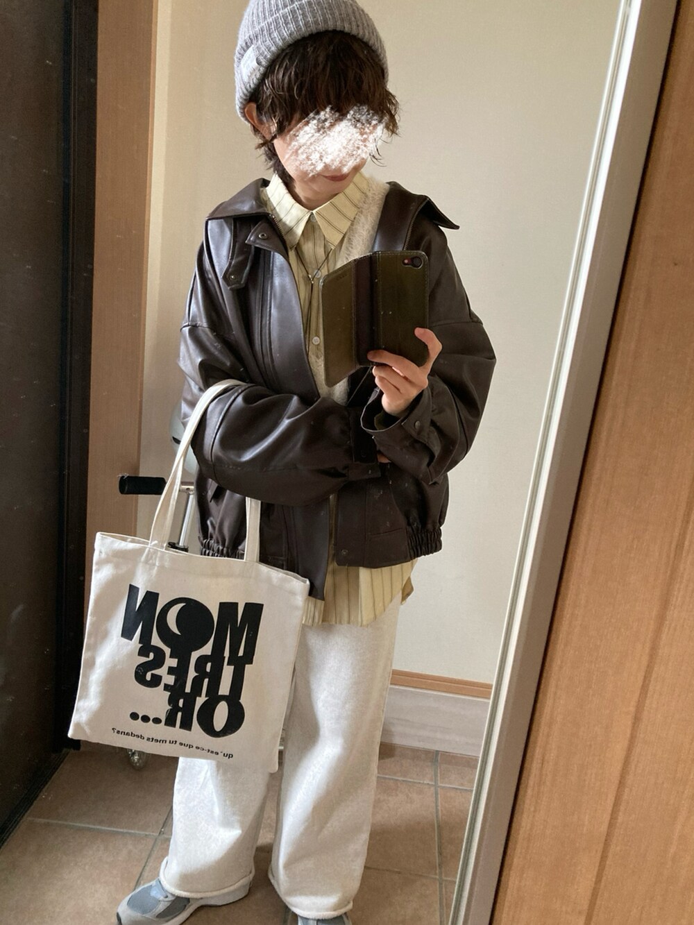 ブラウン系のブルゾン、イエロー系のシャツ/ブラウス、ホワイト系のベストを着用したレディースの春コーディネートの2枚目の写真