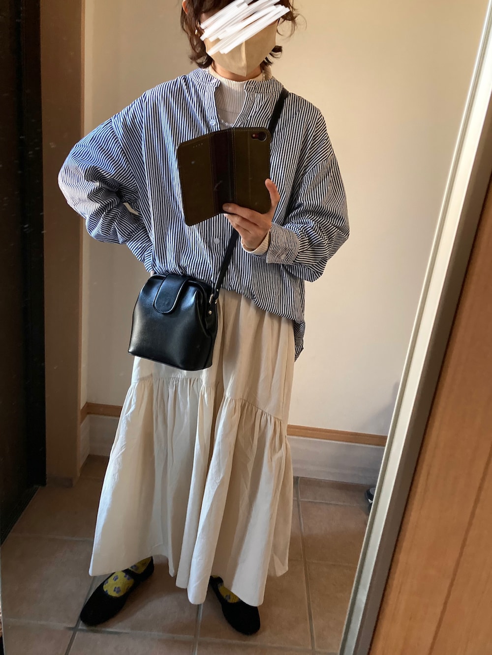 ベージュ系のトレンチコート、ベージュ系のニット/セーター、ブルー系のニット/セーターを着用したレディースの冬コーディネートの2枚目の写真