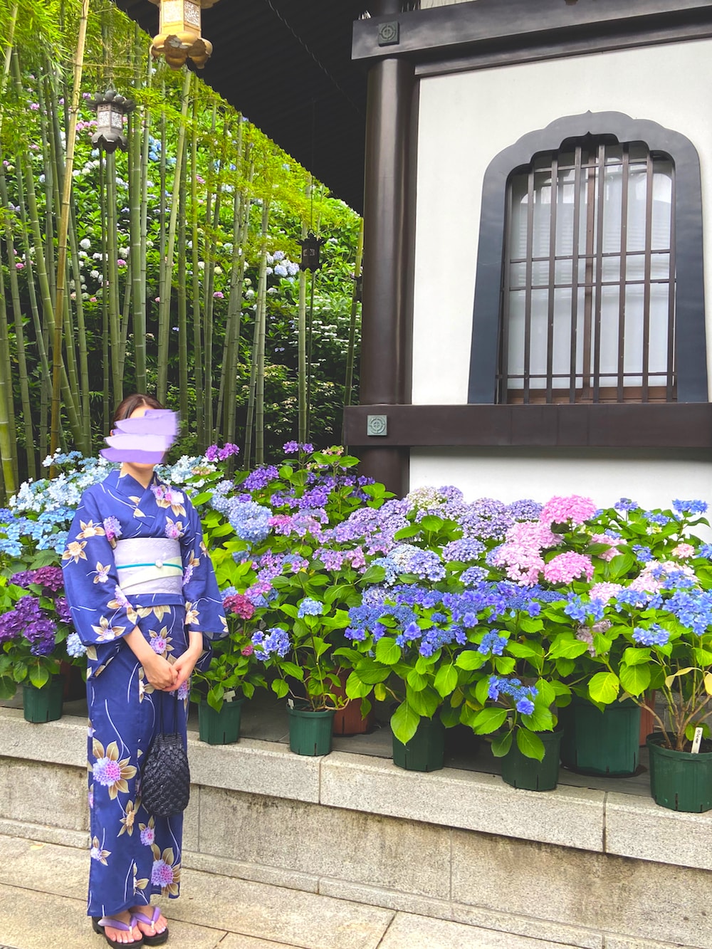 ブラック系のバッグ、ブルー系の浴衣、パープル系の和装小物を着用したレディースの夏コーディネートの2枚目の写真