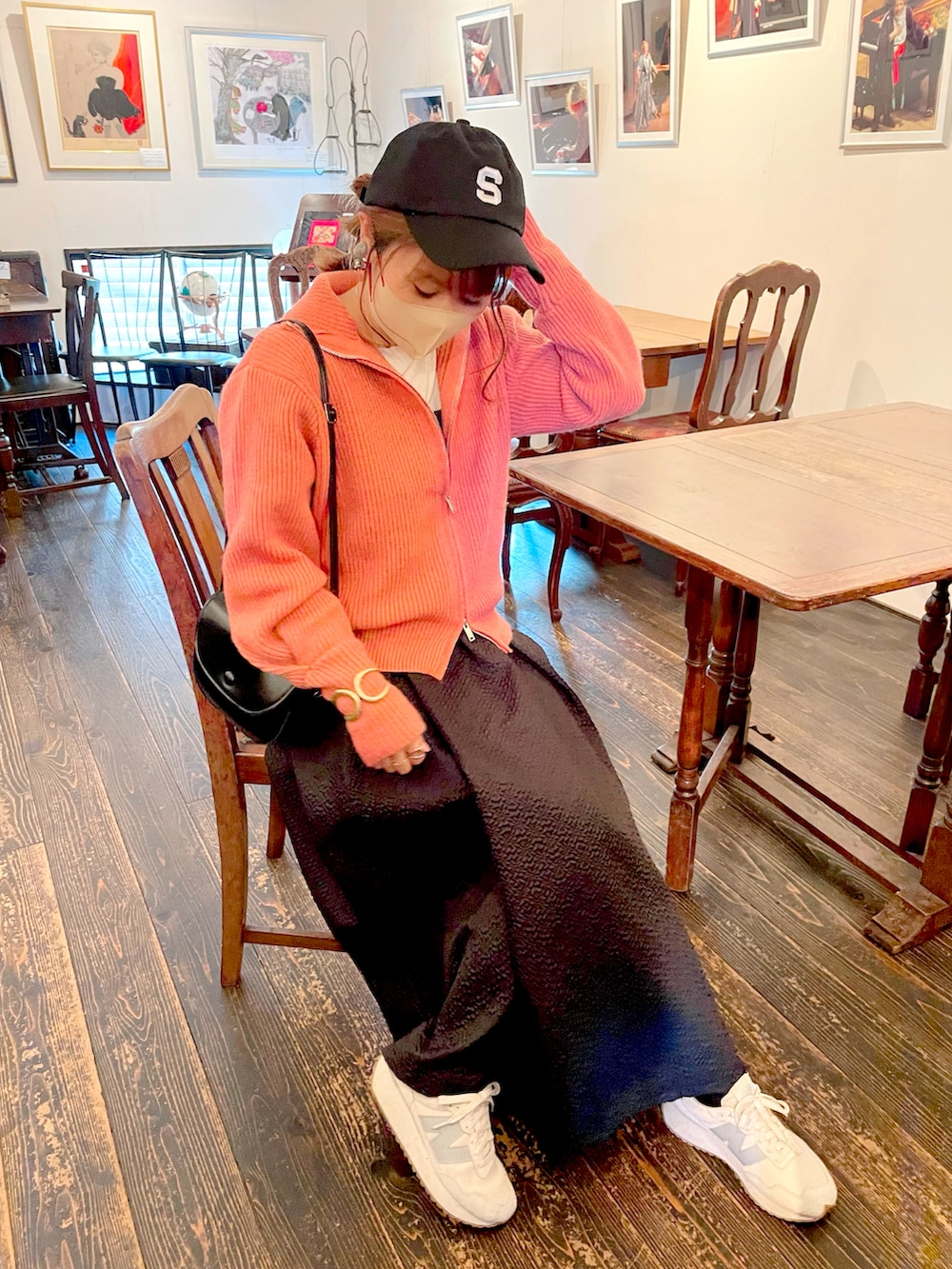 ブラック系のワンピース、ピンク系のニット/セーター、ホワイト系のTシャツ/カットソーを着用したレディースの春コーディネートの5枚目の写真