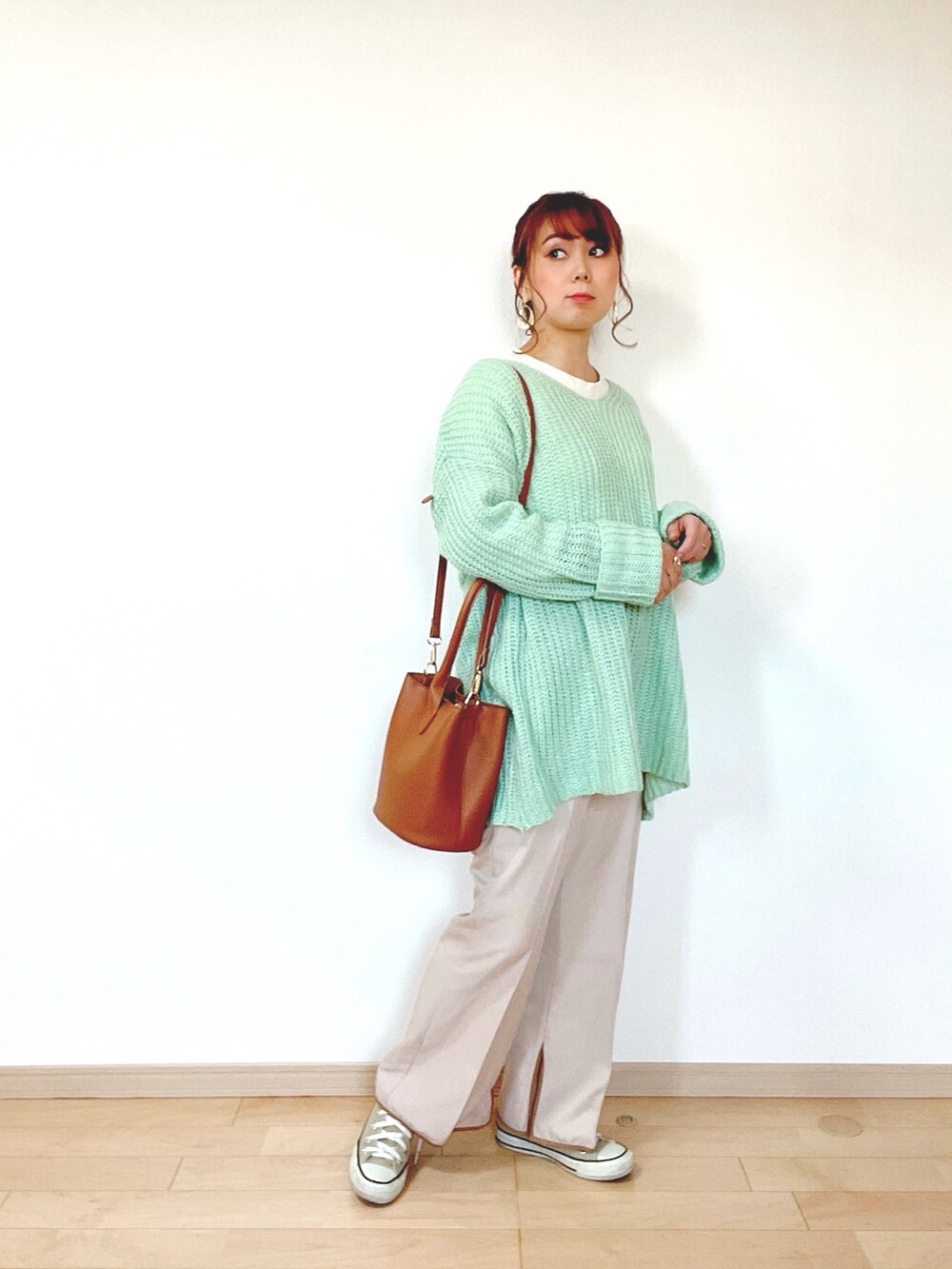 グリーン系のニット/セーター、ホワイト系のTシャツ/カットソー、ベージュ系のその他パンツを着用したレディースの冬コーディネートの3枚目の写真