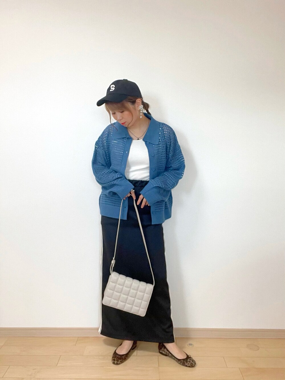 ホワイト系のタンクトップ、ブルー系のカーディガン/ボレロ、ブラック系のスカートを着用したレディースの秋コーディネートの2枚目の写真